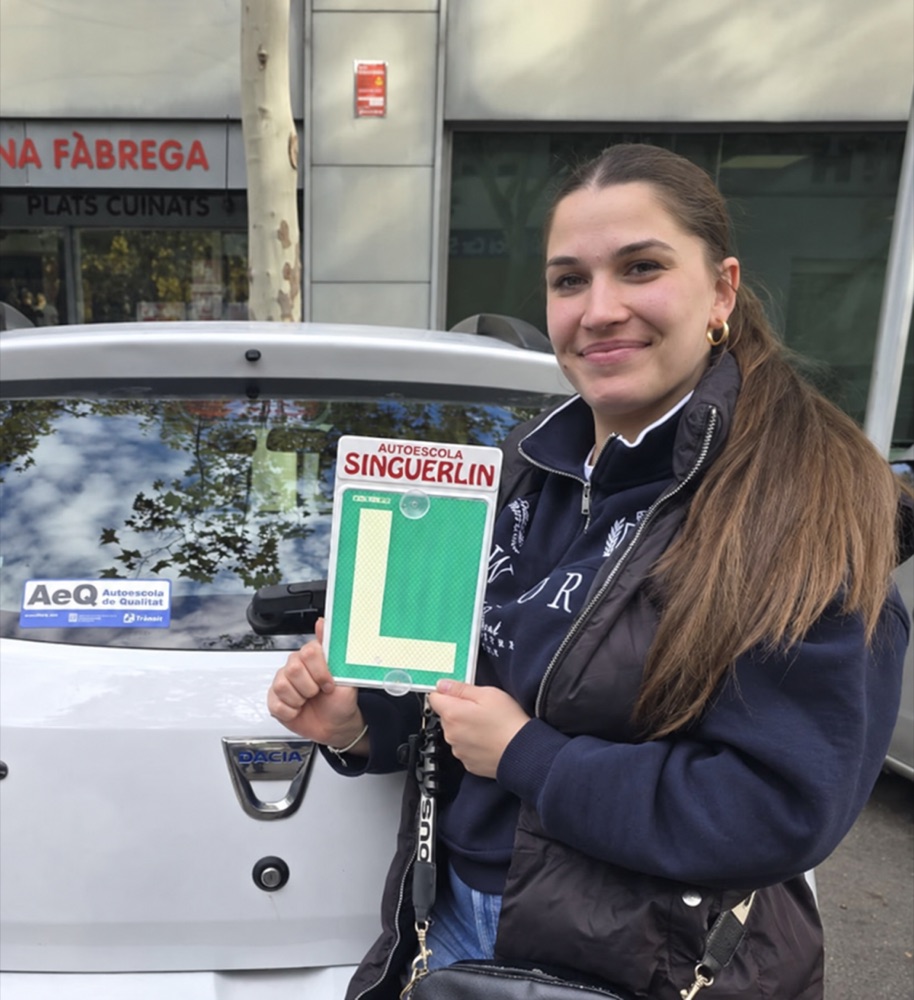 Rosario Amaya celebrando su carnet junto al coche de la autoescuela.